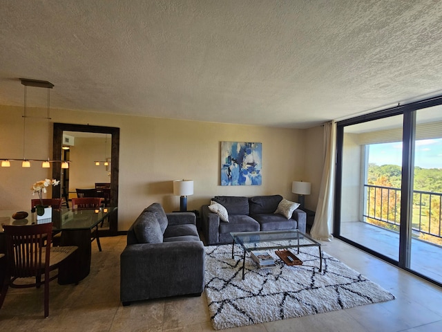 living room featuring a textured ceiling and a wall of windows