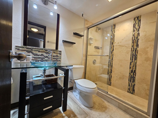 bathroom featuring tile patterned flooring, toilet, an enclosed shower, and sink