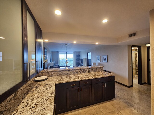 kitchen featuring dark brown cabinetry, light stone counters, sink, and stainless steel appliances