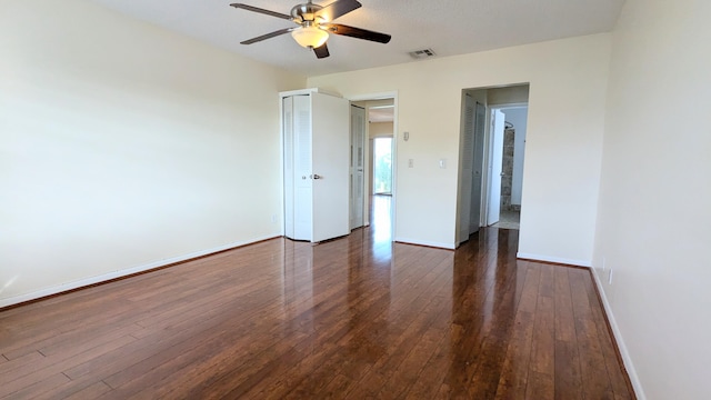 empty room featuring ceiling fan and dark wood-type flooring