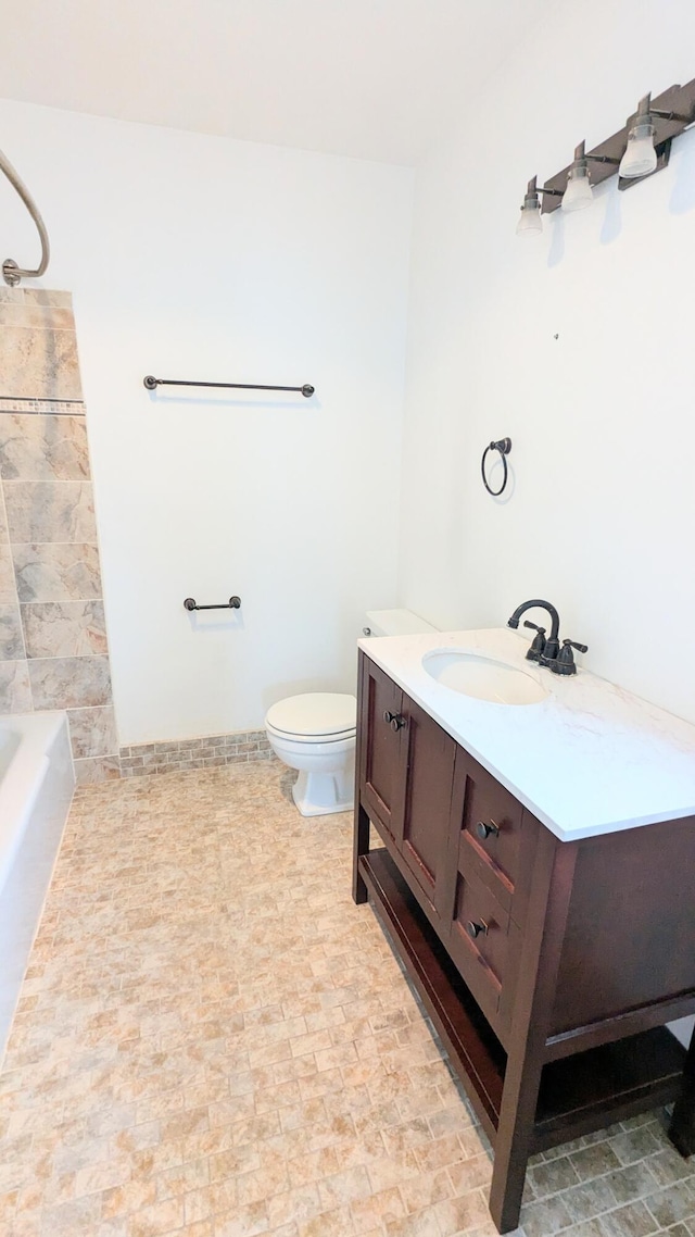 full bathroom featuring washtub / shower combination, vanity, and toilet