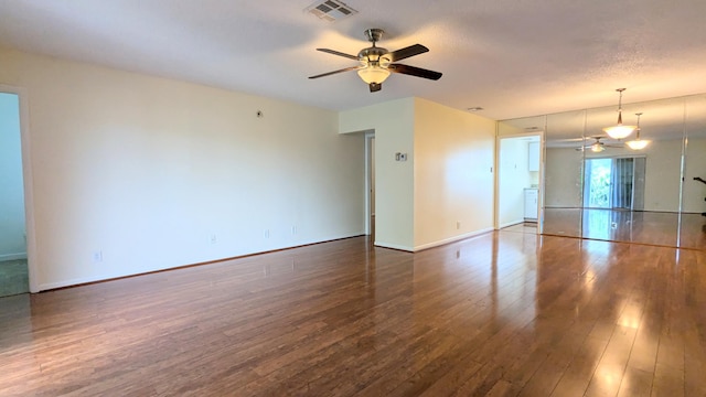 unfurnished living room with ceiling fan, dark hardwood / wood-style flooring, and a textured ceiling