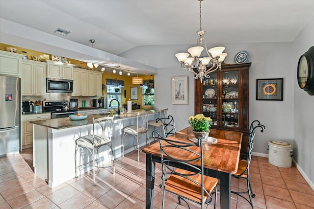 tiled dining space featuring vaulted ceiling, a notable chandelier, and sink