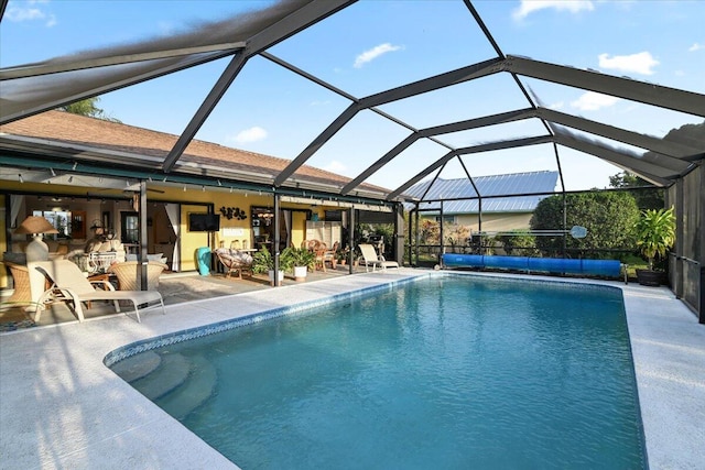 view of swimming pool featuring a lanai and a patio area