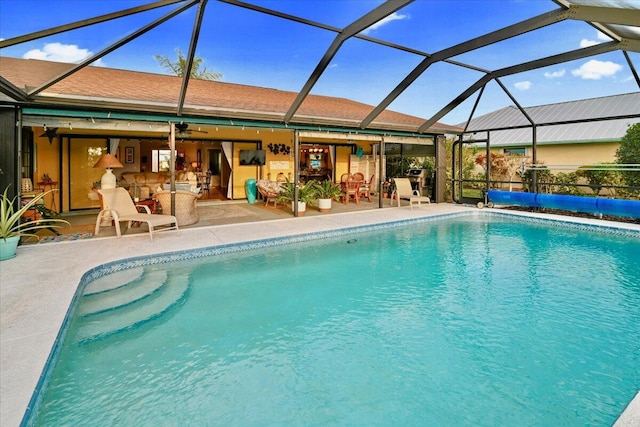 view of swimming pool with a lanai, ceiling fan, and a patio