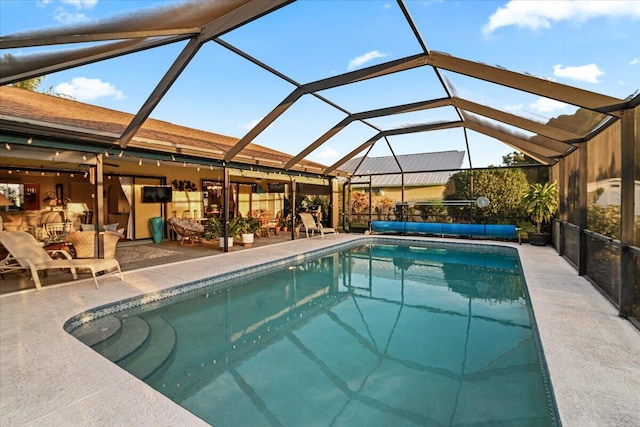 view of swimming pool featuring a patio area and a lanai