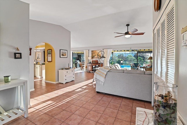 tiled living room featuring ceiling fan, sink, and high vaulted ceiling