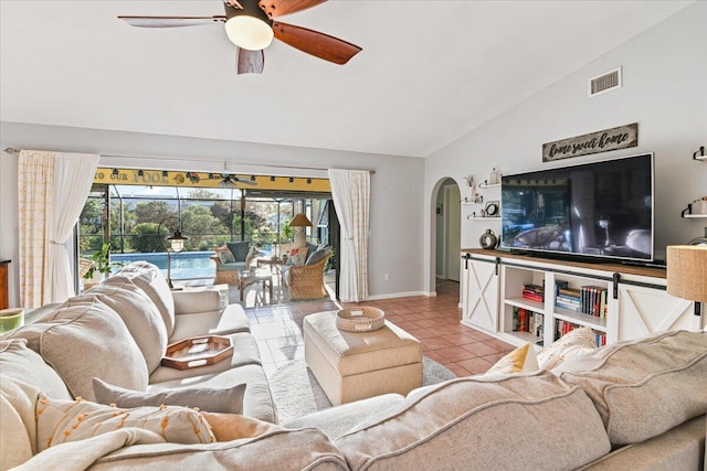 tiled living room with ceiling fan and vaulted ceiling