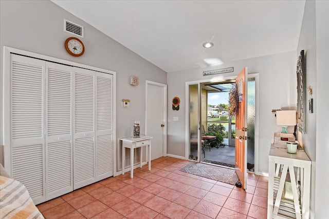 doorway to outside featuring light tile patterned flooring and vaulted ceiling