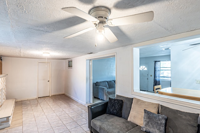 living area with a textured ceiling and ceiling fan