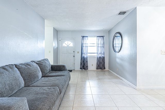 living room featuring light tile patterned floors and a textured ceiling