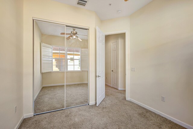 unfurnished bedroom featuring light carpet and a closet