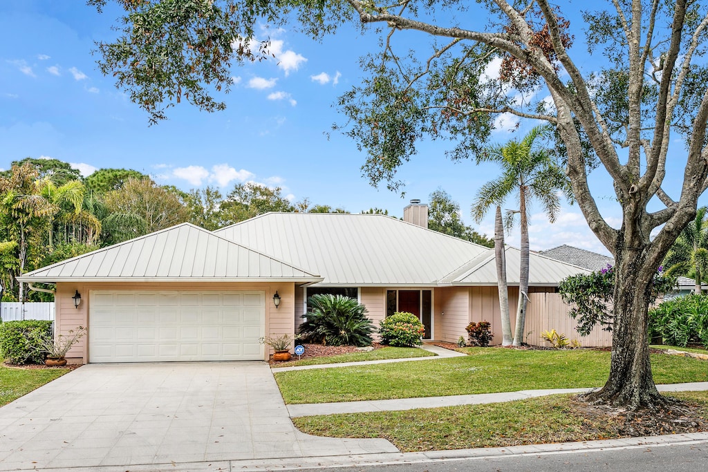 ranch-style home with a front lawn and a garage