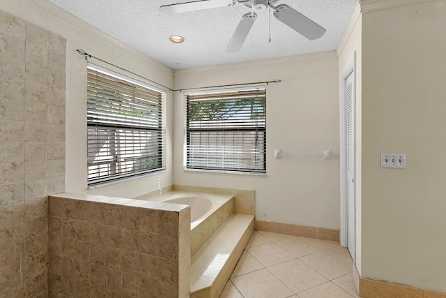 bathroom with tile patterned floors, ceiling fan, ornamental molding, a textured ceiling, and tiled bath