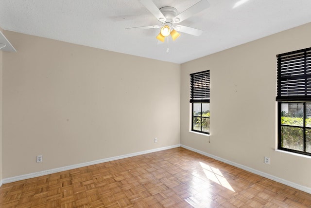 empty room with a textured ceiling, light parquet floors, and ceiling fan