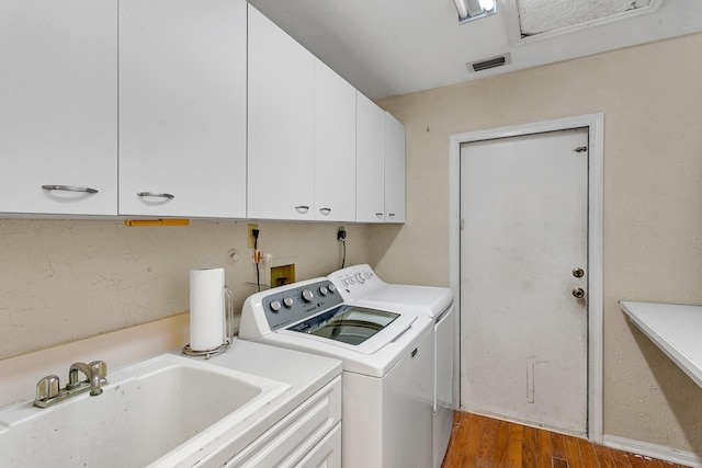 laundry room with cabinets, separate washer and dryer, dark wood-type flooring, and sink