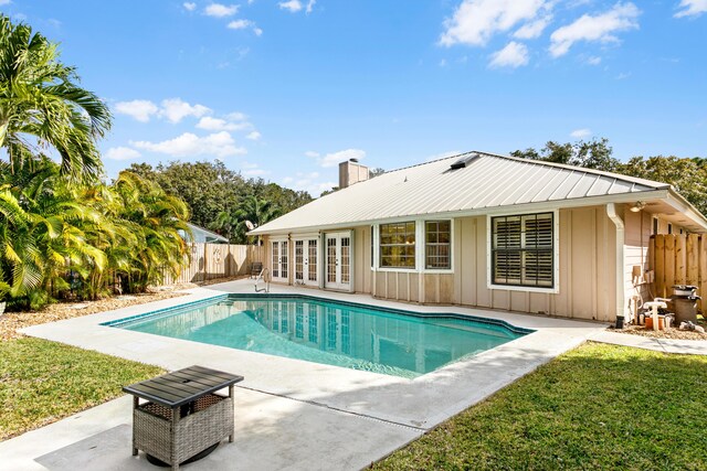 view of pool with a patio area, a yard, and french doors