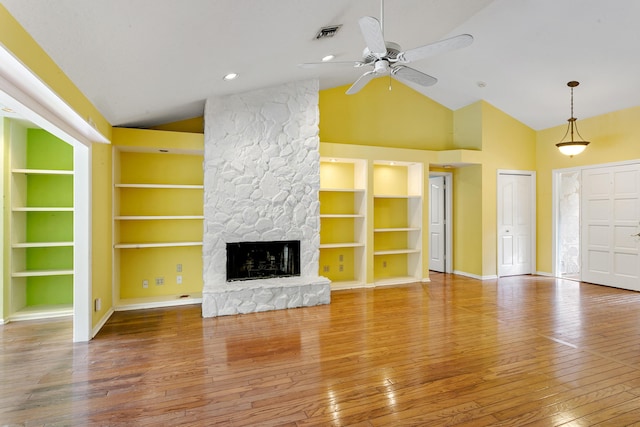 unfurnished living room featuring high vaulted ceiling, hardwood / wood-style flooring, ceiling fan, built in features, and a fireplace