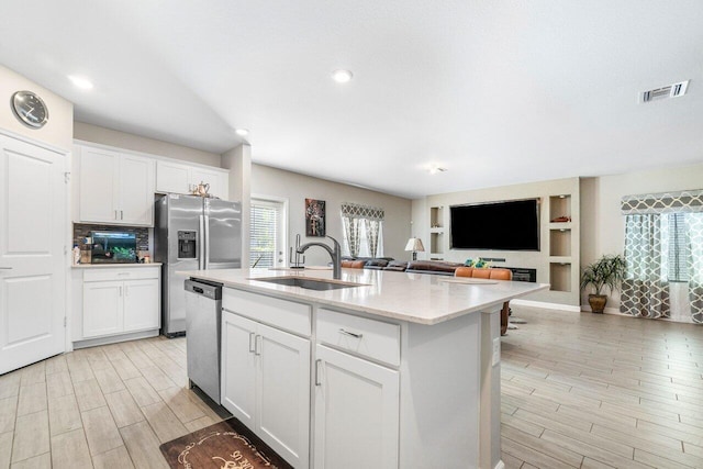 kitchen with sink, white cabinetry, a kitchen island with sink, and appliances with stainless steel finishes