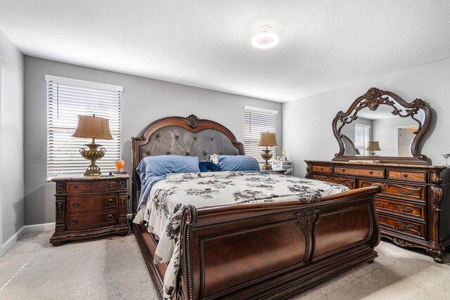 bedroom with light colored carpet and multiple windows