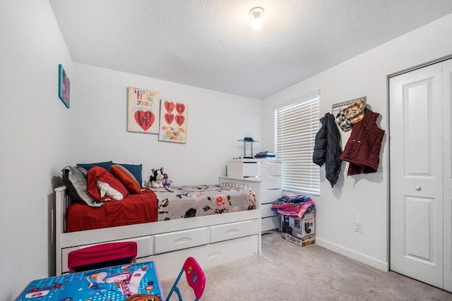 bedroom featuring a textured ceiling, carpet floors, and a closet