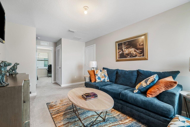 carpeted living room featuring a textured ceiling