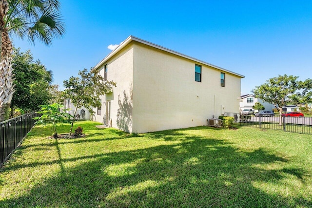 back of property with central air condition unit and a lawn