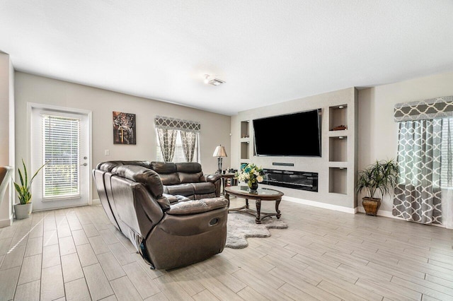 living room featuring built in features and plenty of natural light