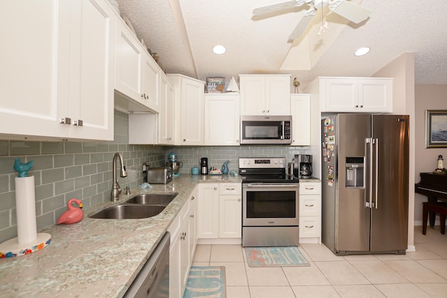 kitchen featuring light tile patterned flooring, white cabinetry, stainless steel appliances, and a sink