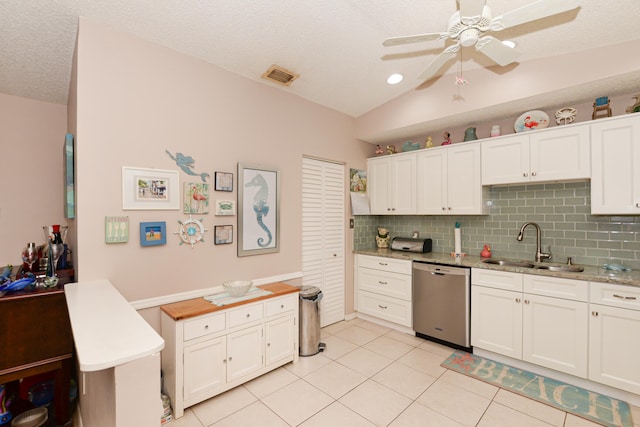 kitchen featuring light tile patterned floors, visible vents, a sink, vaulted ceiling, and dishwasher