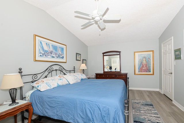 bedroom featuring baseboards, a ceiling fan, lofted ceiling, and wood finished floors