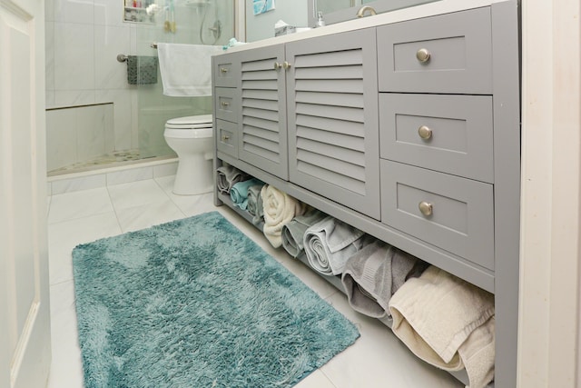 bathroom featuring tile patterned flooring, a shower stall, and toilet