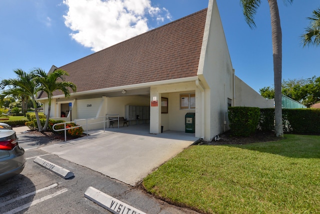 view of front of house featuring stucco siding, a shingled roof, and a front yard