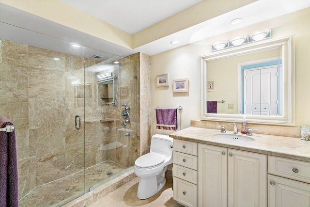 bathroom with vanity, toilet, and a shower with door