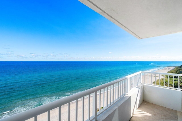 balcony with a water view and a view of the beach