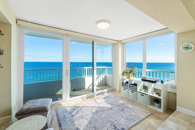 sunroom featuring plenty of natural light and a water view