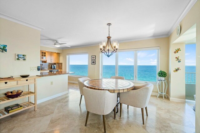 dining room with a healthy amount of sunlight, a water view, and crown molding