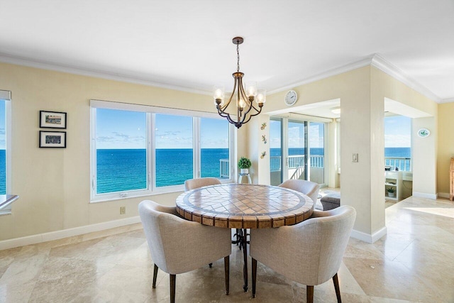 dining space with a notable chandelier, a water view, and crown molding