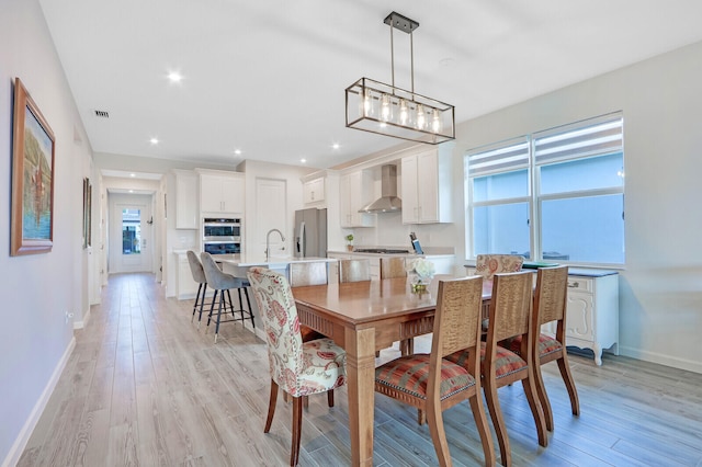 dining area with light hardwood / wood-style floors and sink