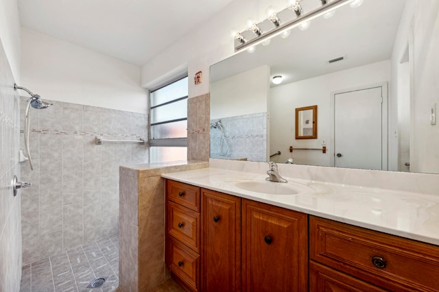 bathroom with vanity and a tile shower