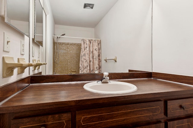 bathroom with hardwood / wood-style floors, vanity, and walk in shower