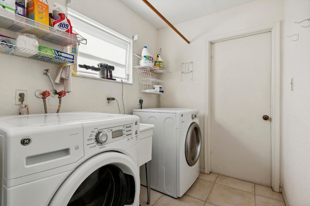 clothes washing area featuring light tile patterned floors and separate washer and dryer