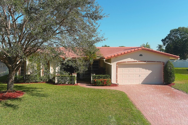 mediterranean / spanish-style home with a front yard and a garage