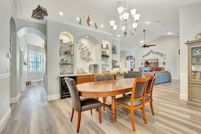 dining space with ceiling fan with notable chandelier, light wood-type flooring, wine cooler, and crown molding