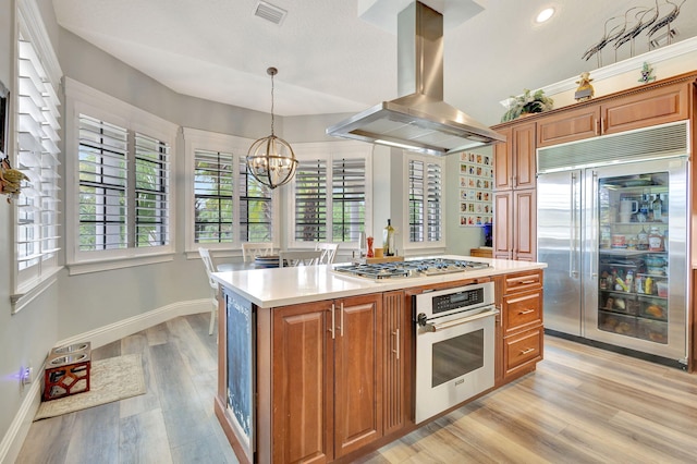 kitchen with a center island, light hardwood / wood-style flooring, decorative light fixtures, island exhaust hood, and stainless steel appliances