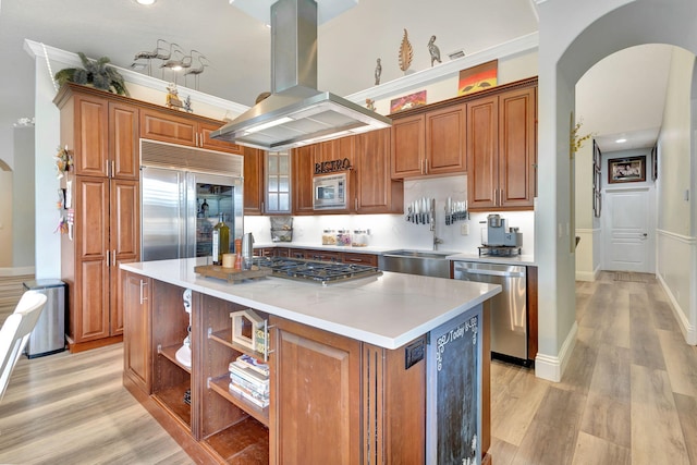 kitchen featuring sink, built in appliances, light hardwood / wood-style floors, island range hood, and a kitchen island