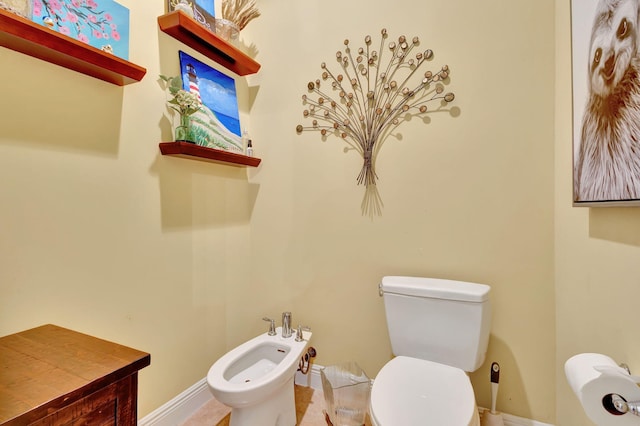 bathroom featuring tile patterned floors, toilet, and a bidet