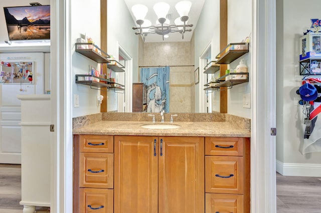 bathroom featuring hardwood / wood-style floors, vanity, and a notable chandelier