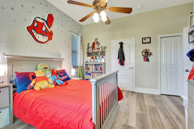 bedroom with light hardwood / wood-style flooring, vaulted ceiling, and ceiling fan