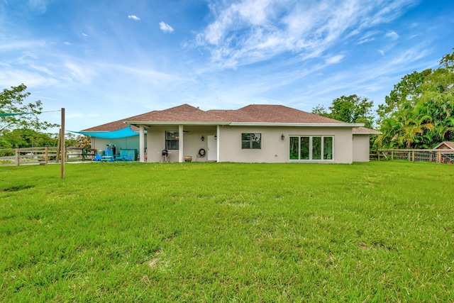 back of property featuring a lawn